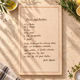 Schneidebrett mit eingravierter Handschrift, Rezept Omas Apfelkuchen, Ansicht von oben